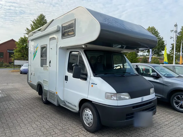 Weißes Reisemobil mit Alkoven in der Frontansicht