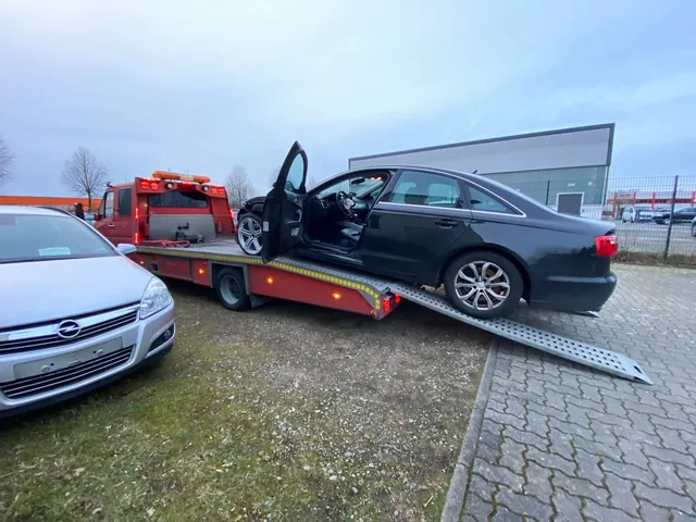 Dunkle BMW-Limousine auf der Ladefläche eines Abschleppwagens