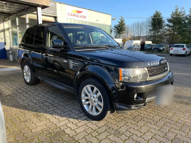 Schwarzer Range Rover vor einem Werkstattgebäude